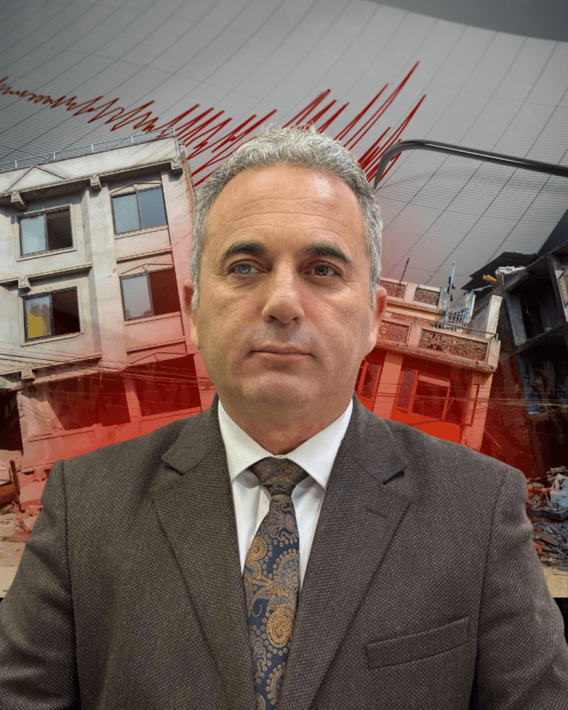 Fotoğrafın merkezinde, göğüs hizasından yukarısı görünen, orta yaşlarda bir erkek yer almaktadır. Erkek kameraya doğrudan bakmaktadır. Saçları kısa, griye dönmüş ve düzenlidir. Yüz ifadesi ciddi, sakin ve kararlıdır; gülümseme yoktur. Kaşları belirgin, gözleri dikkatli ve odaklanmış bir bakışa sahiptir. Üzerinde koyu kahverengi tonlarında, klasik kesim bir takım elbise ceketi bulunmaktadır. Ceketin altında açık renk bir gömlek ve desenli, koyu tonlarda bir kravat takılıdır. Kıyafeti resmi ve profesyonel bir görünüm vermektedir; bir uzman, yetkili ya da konuşmacı izlenimi uyandırmaktadır. Arka plan gerçek bir mekân değildir; dijital olarak oluşturulmuş veya düzenlenmiş bir kompozisyon izlenimi verir. Arka planda, depremden zarar görmüş binalar yer almaktadır. Binaların cephelerinde yıkımlar, kırılmış pencereler ve dökülmüş betonlar görülmektedir. Sağ tarafta molozlar ve çökmüş yapı kalıntıları dikkat çekmektedir. Arka planın üst kısmında, kırmızı renkte zikzaklı çizgiler bulunmaktadır. Bu çizgiler bir deprem sismografı kaydını çağrıştırmaktadır ve depremi, sarsıntıyı ve tehlikeyi simgelemektedir. Kırmızı renk, görselde alarm, aciliyet ve risk duygusunu güçlendirmektedir.